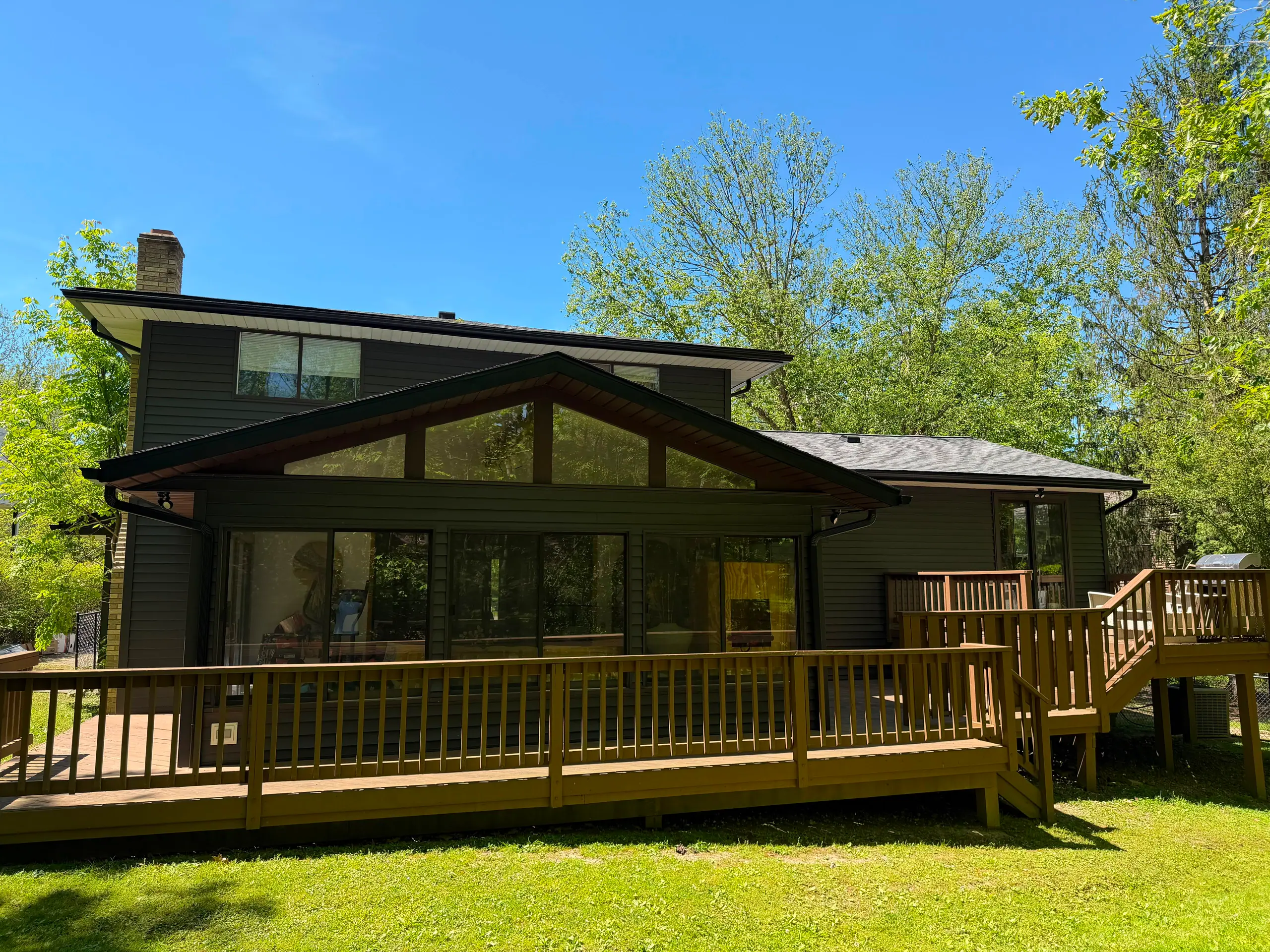 A large two-story home with a new dark roof, black seamless gutters and fresh siding, finished by Predey's Roofing in the Greater Cleveland area.